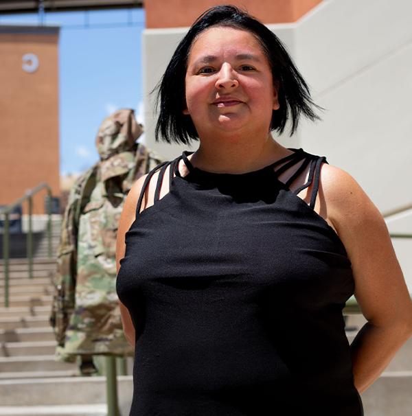 安吉Buenrostro stands smiling at Northwest Campus, her uniform in the background