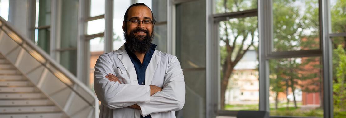 Jorge Muñoz stands in the lobby of the Health Science Center at NAU