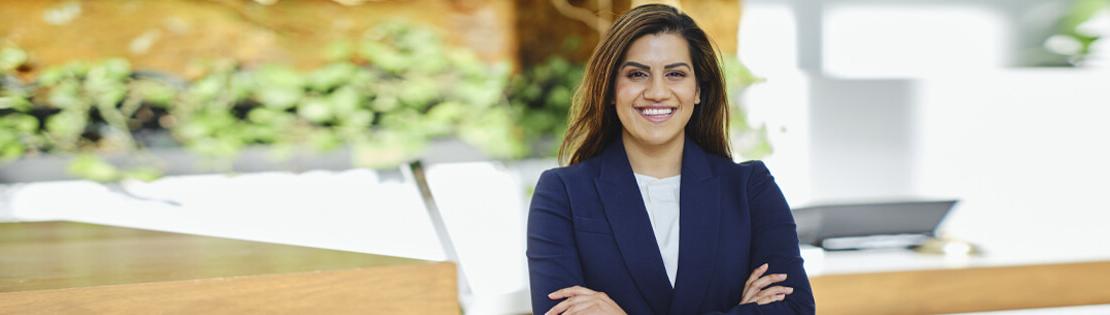 A hotel manager stands posing for the camera outside of a hotel