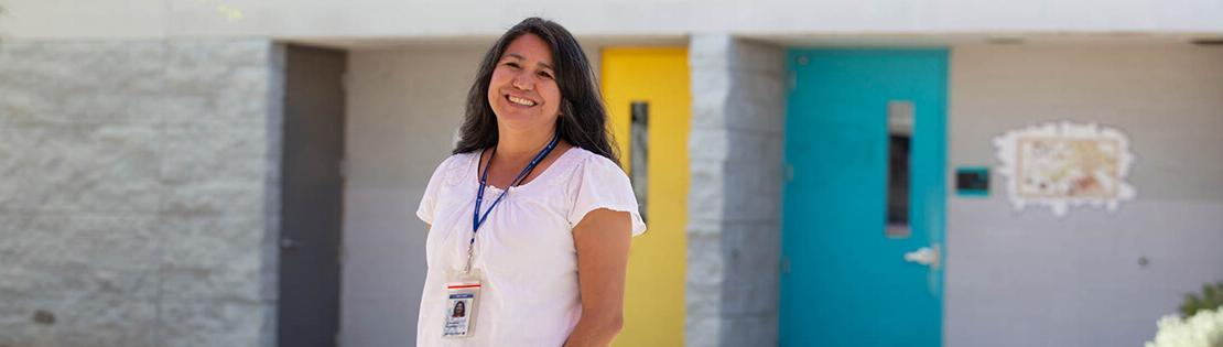 A Pima Faculty Member smiles in a courtyard at a Pima Adult Learning Center